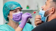 Healthcare worker testing a patient for COVID